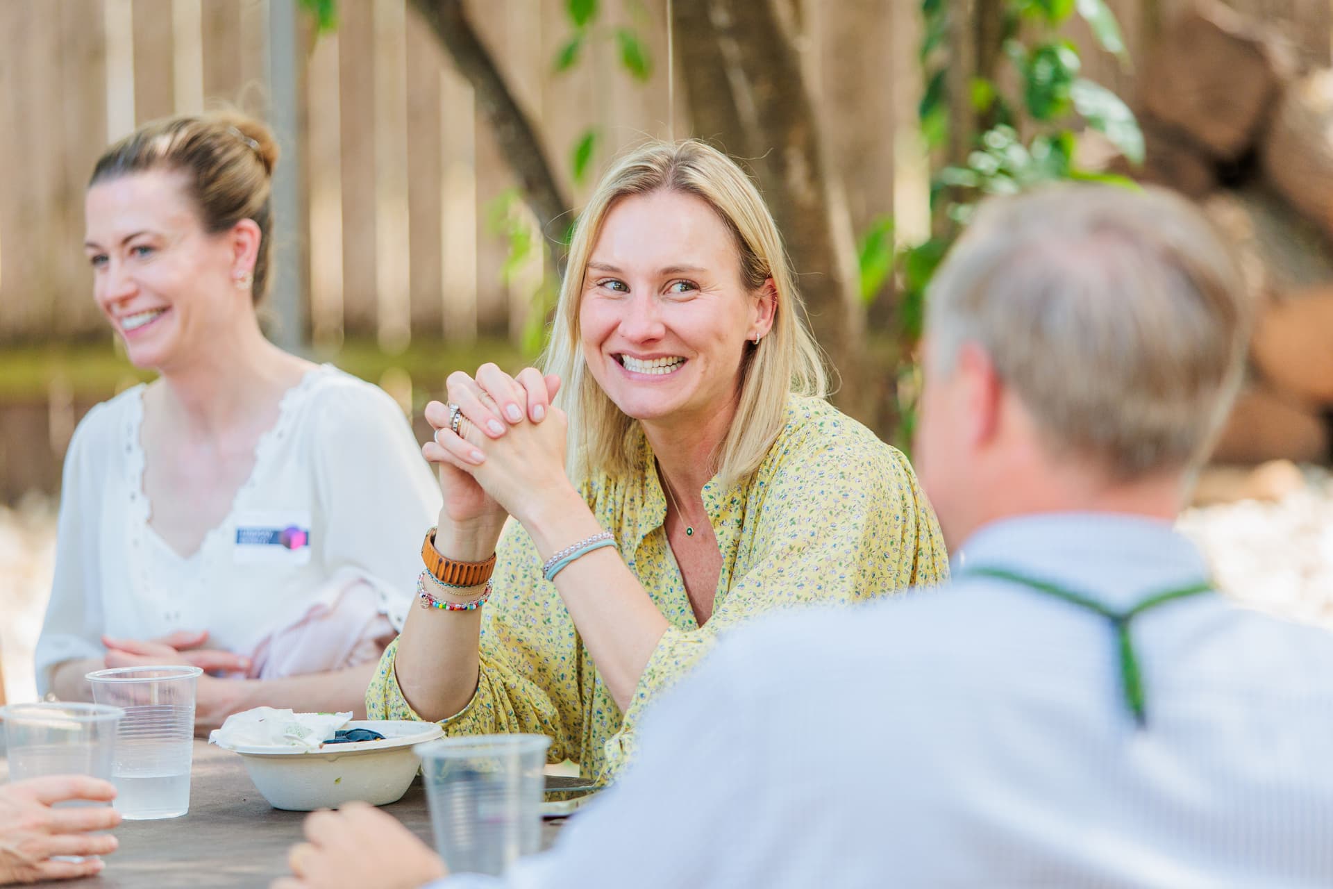 Two professionals engaged in a genuine candid conversation at a corporate networking event, natural expressions and body language