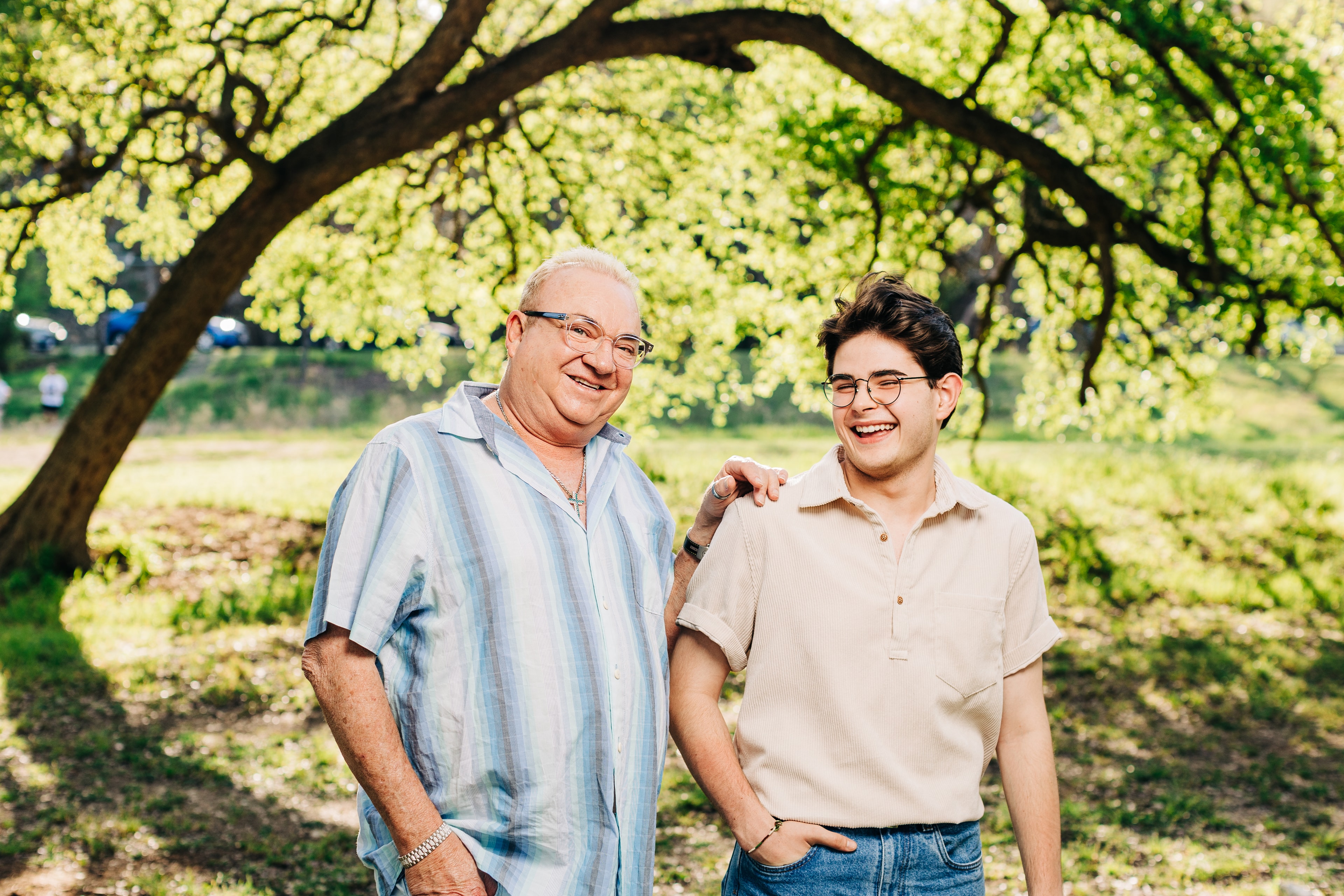 moment of connection of a father with his teenage son, laughing, smiling, with natural light in an outdoor setting