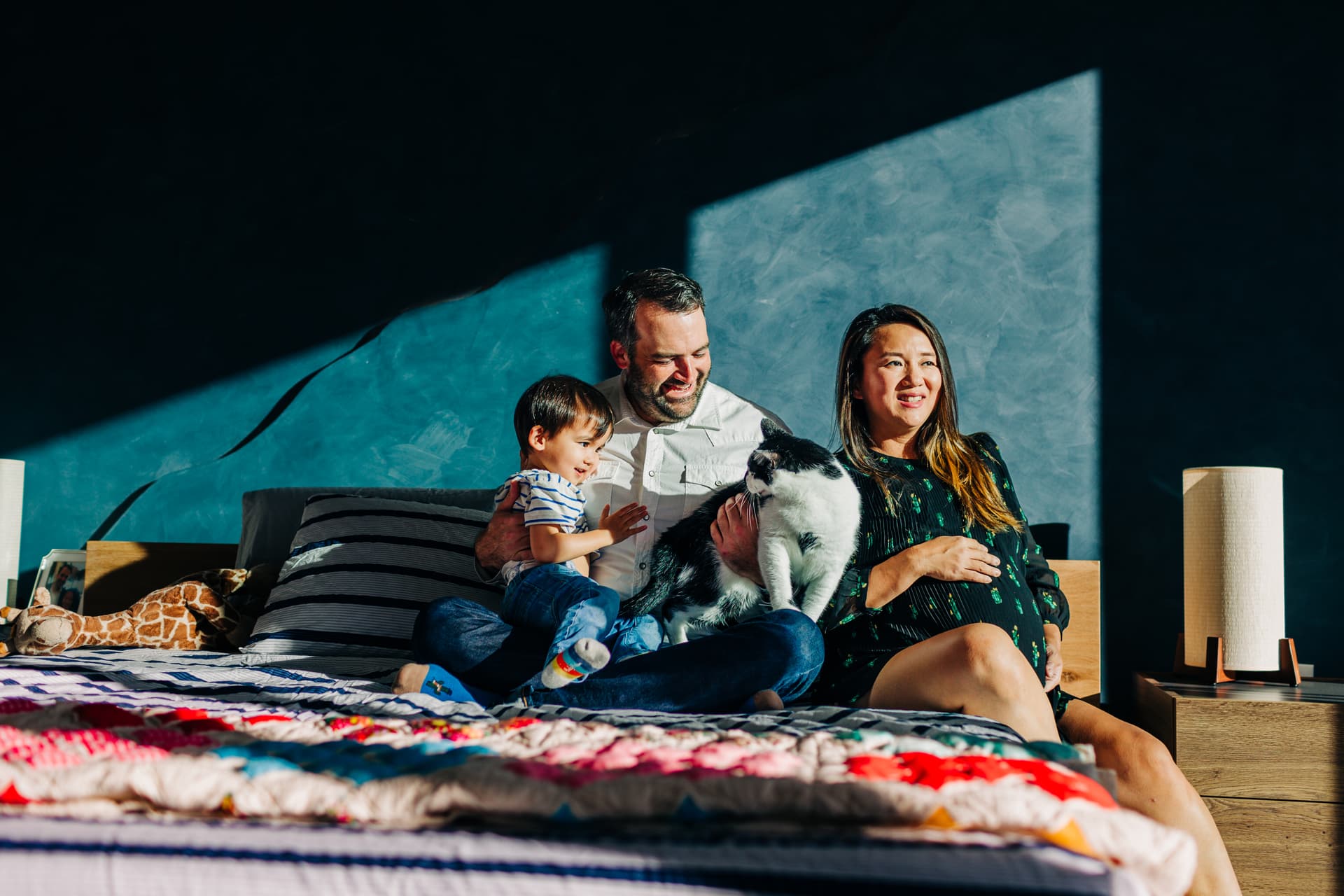 Genuine family laugh moment — the whole family cracking up together during a session, heads thrown back, scrunched-up noses, the kind of unposed joy that makes the best family photos