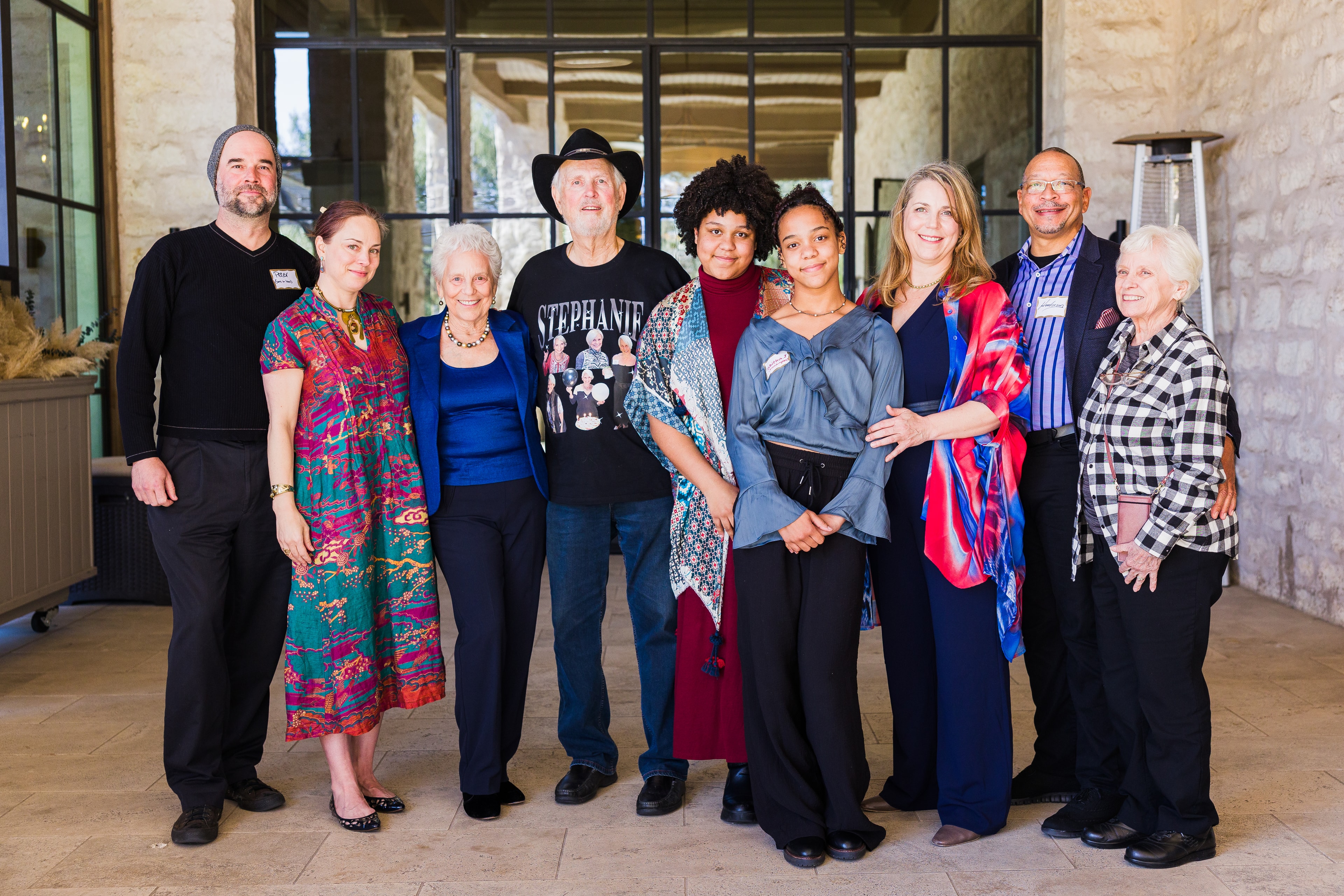 Multi-generational family portrait — great-grandparents, grandparents, parents, and children all together in one frame, showing the full span of a family gathered for a milestone celebration