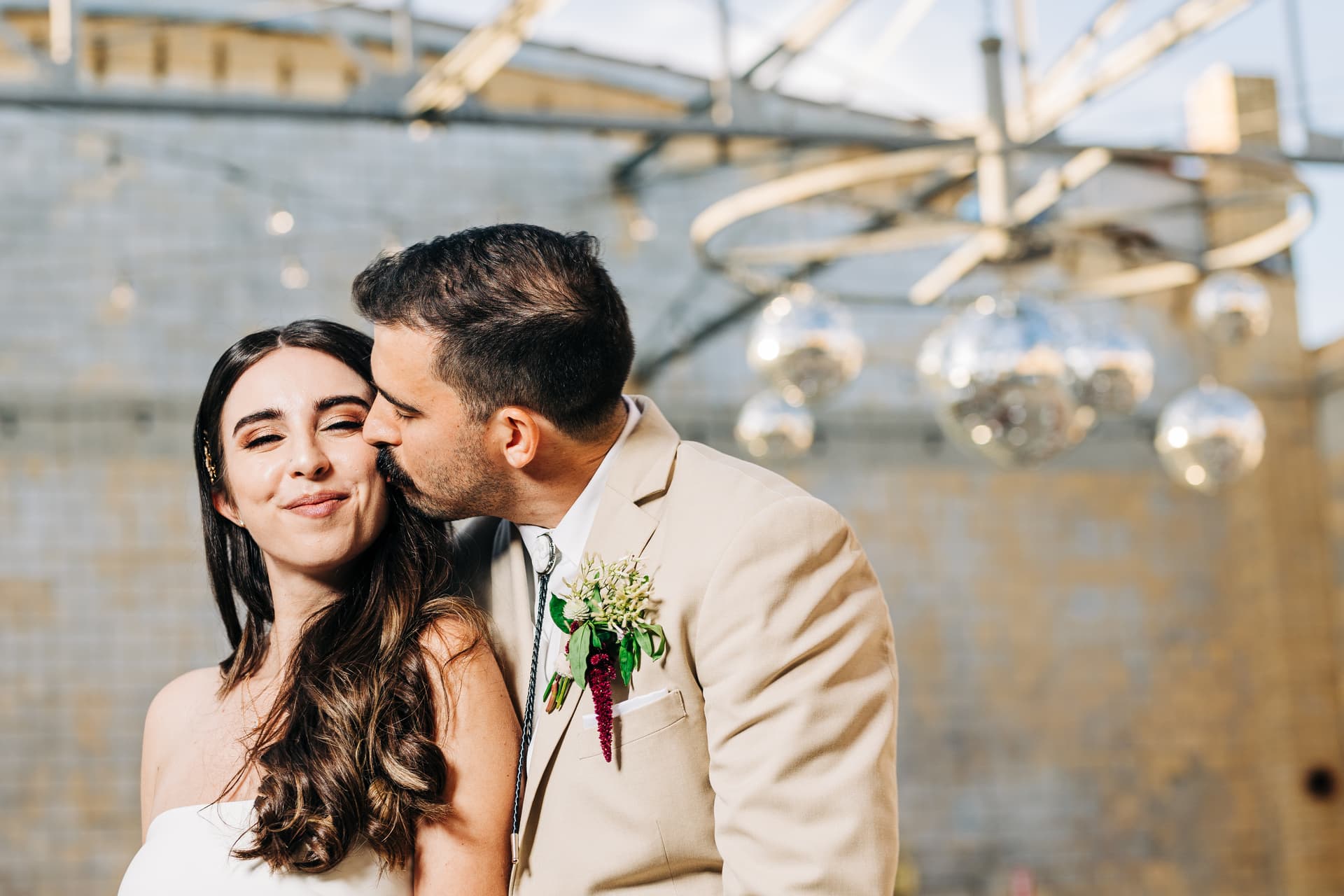Couple portrait inside the industrial Martindale Schoolhouse with open ceiling, textured walls, and dramatic natural light streaming in