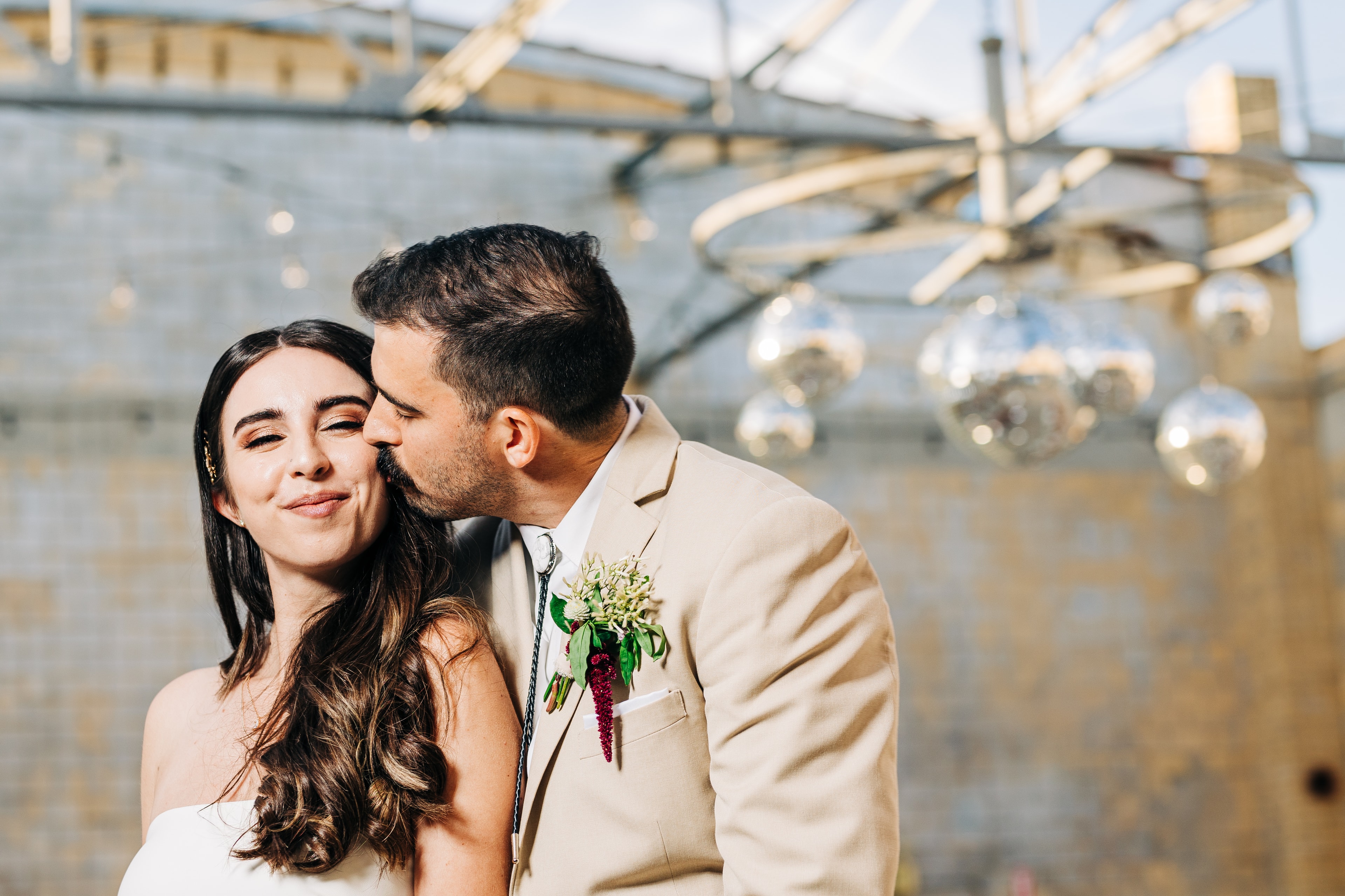 Couple portrait inside the industrial Martindale Schoolhouse with open ceiling, textured walls, and dramatic natural light streaming in